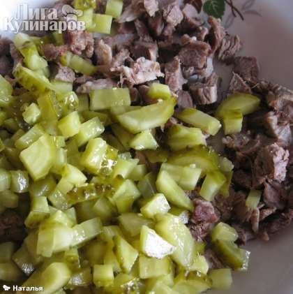 Огурец нарезать кубиками и добавить в нарезанное мясо