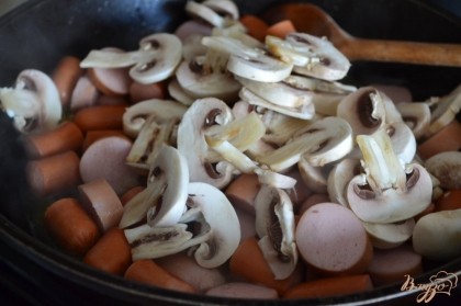 Шампиньоны промыть и нарезать тонко. Выложить в сковроду.Накрыть крышкой, потушить в течении 10 минут.