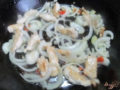 Разогреть сковороду с маслом и выложить сначала мясо курицы (нарезать полосками 2 сантиметра). Жарить минуты 2 до белого цвета. Следом выложить лук репчатый, нарезанный полукольцами. Убавить огонь и жарить до мягкости лука. Добавить перец чили.