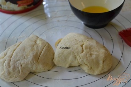 Тесто выложить на поверхность с припыленной мукой, помять. Разделить на 2 части.