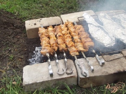 На шампур насаживайте и мясо и лук чередую. Жарят куриный шашлык на углях среднего жара. Готовность проверяйте сделав надрез. Оставшийся сок лимона смешайте с минералкой и поливайте во время приготовления шашлык.