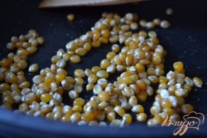 В сковороду налить оливковое масло и выложить кукурузные зерна.Хорошо перемешать, чтобы все зерна покрылись маслом. Огонь сделать умеренный.