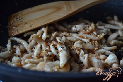 На оливковом масле обжарить до золотистого цвета куриное мясо, нарезанное тонкими полосками.Добавить специи и кунжутное семя.