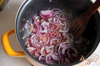 Нарезать лук кольцами/полукольцами. Грудинку - соломкой/кубиками. В разогретый казан или сотейник положить грудинку, растопить немного, добавить лук. Поджарить его до золотистости.