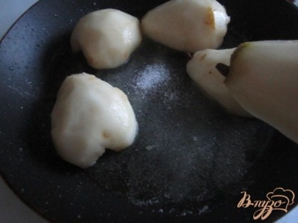 На сковороде растопить сливочное масло, посыпать сахаром и уложить груши.