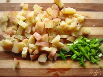 Картофель отварите в мундирах и нарежьте на кусочки. Зеленый лук мелко нарежьте.
