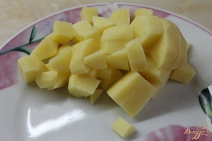 Картофель нарезать средним кубиком и добавить к ребрам.