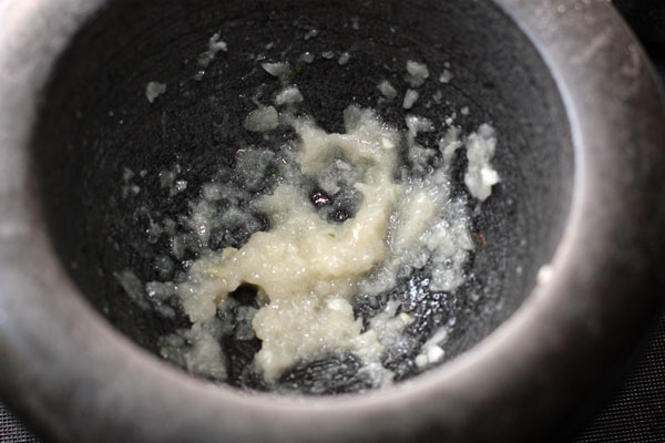 Нарежьте чеснок и растолките его в ступке с солью до пюреобразного состояния.
