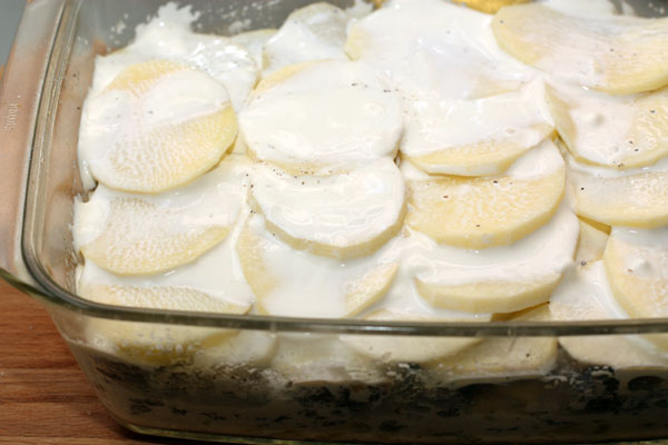 Смешать оставшиеся сливки со сметаной до однородности и покрыть верхний картофельный слой запеканки. Соль-перец не забудьте (количество указываю в этом этапе суммарное для всей запеканки).