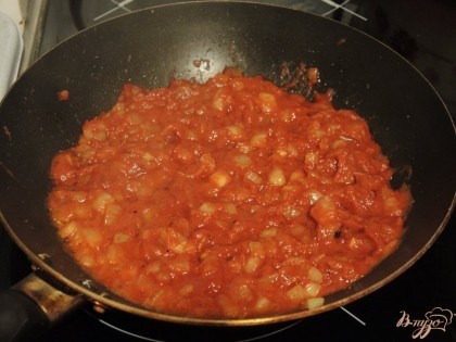 Как только лук станет мягким, слегка пожелтеет - добавляем в него томатную пасту и немного воды. Даем луково-томатной зажарке слегка выпариться.