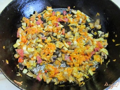 Мелко нарезать грибы и добавить к овощам. Жарить на среднем огне еще минут пять. Я еще добавила колбасу, но это не обязательно, просто я утилизировала остатки.