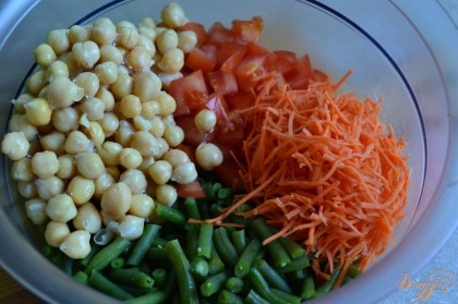 В салатник  выложить кусочки помидора, добавить соломку из свежей моркови, промытый консервированный нут.