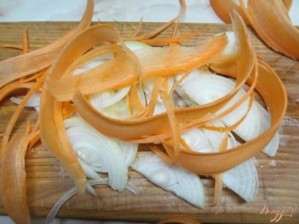 Лук и морковь нарезать произвольно и жарить на среднем огне до мягкости.