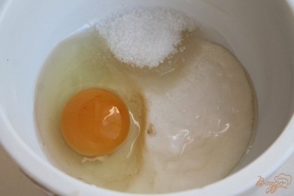 В пиалу наливаем ряженку, добавляем сахар и яйцо.  Все тщательно перемешиваем, можно воспользоваться блендером.