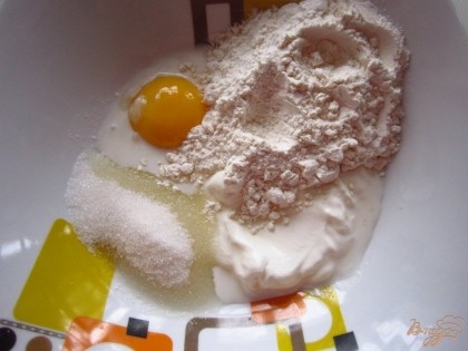 В миску положите желток, сахар, муку смешанную с содой, сметану, взбейте миксером до однородности.