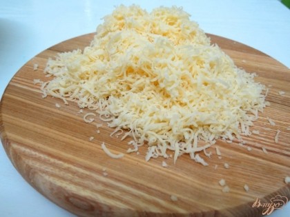 Сыр натираем на мелкой тёрке и половину добавляем в тесто.