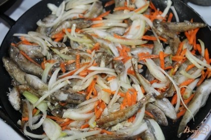 Добавить овощи к рыбе и жарить до полу готовности.