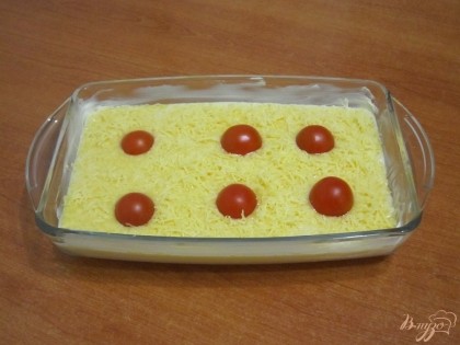 Сверху посыпать натертым сыром и разложить помидоры черри.