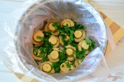 Итак начинаем формировать салат. Берем подходящую емкость, выстилаем пищевой пленкой. Первым слоем идут грибы. Шампиньоны нам нужны с цельной шляпкой. Выкладываем грибы шляпкой вниз и посыпаем рубленной зеленью