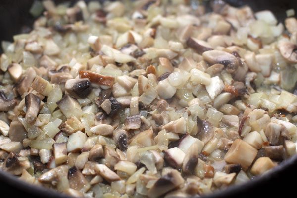 Отправьте грибы к луку и готовьте все вместе 5-7 минут на среднем огне.