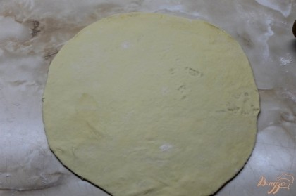 Далее раскатать тонко тесто для пиццы и вырезать с помощью круглой доски заготовку.