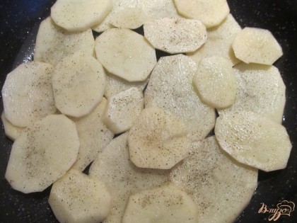В большую сковороду на дно кладем картофель, солим, перчим.