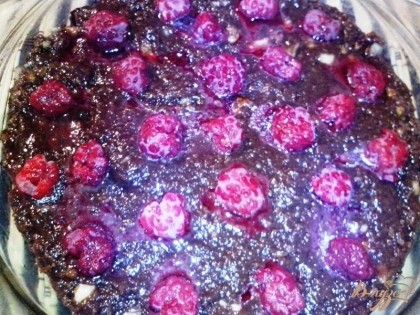 Выложить ровным слоем в форму или на блюдо. Сверху уложить ягоды малины (свежие или замороженные). Если используются замороженные ягоды, то их нужно предварительно разморозить.