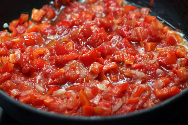 Теперь добавьте очищенные от кожицы и мелко нарезанные помидоры. Тушите еще 10 минут.