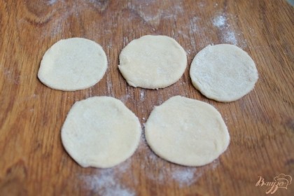 Тесто делим на 3 части. Одну часть раскатываем толщиной 1 мм и вырезаем круги с помощью формы или рюмки. Оставшееся тесто ждет своей очереди под пищевой пленкой.
