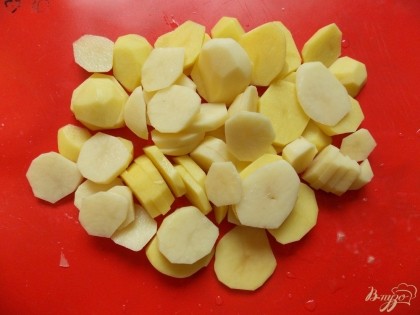 Картофель помыть, очистить от кожуры, порезать на кружочки и положить на лук.