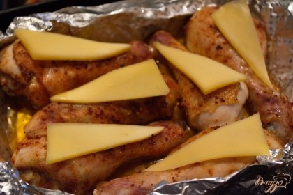 Достаньте ножки из духовки. На каждую уложите по кусочку сыра. Верните в духовку до расплавления сыра. Долго запекать не надо, иначе сыр пересохнет.