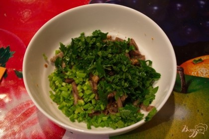 Из сковороды перекладываем говядину в салатник. Добавляем нарезанные петрушку и зеленый лук.