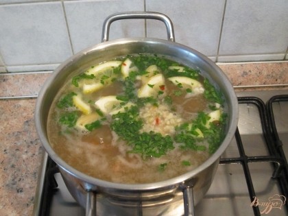 Суп заправить толченым чесноком, томатной пастой, добавить дольки лимона, зелень.