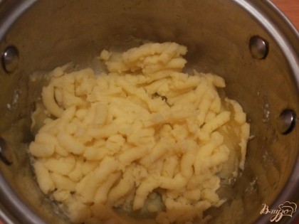Картофель сварился, сливаем жидкость и измельчаем толкушкой.