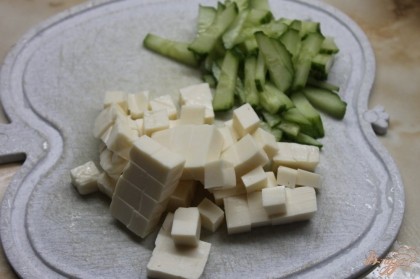 Огурец для салата нарезать мелкой соломкой, сыр плавленный мелким кубиком.