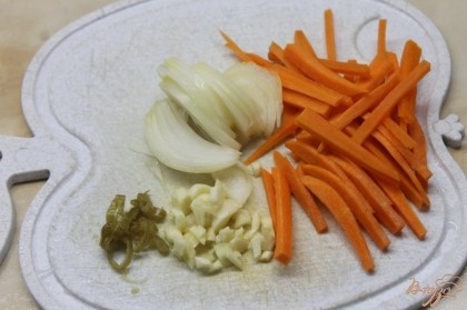 Далее нарезать овощи. Лук репчатый полукольцами, морковь мелкой соломкой, чеснок мелким кубиком.