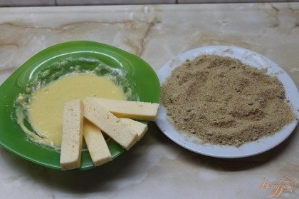 Окунаем сырную палочку сначала в кляр потом в панировочные сухари.
