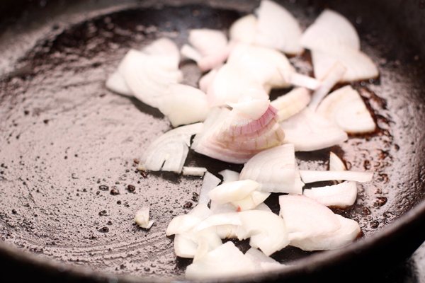 Переложите мясо в другую посуду, а на сковороде обжарьте в течение 1-2 минут нарезанный четверть-кольцами лук вместе с чайной ложкой кукурузной муки.