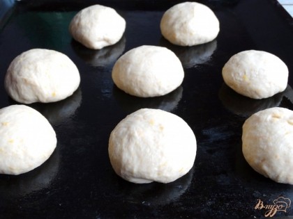 После подъема тесто готово к дальнейшей работе. Разделите его на равные части примерно по 60-70 граммов. Скатайте круглые булочки.