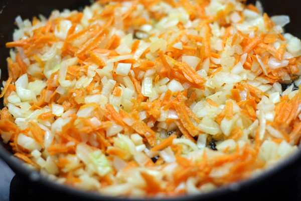 Спассеруйте на среднем огне мелко нарезанный лук (2 небольшие луковицы) и натертую на крупной терке морковь до мягкости. Это займет 3-5 минут. 