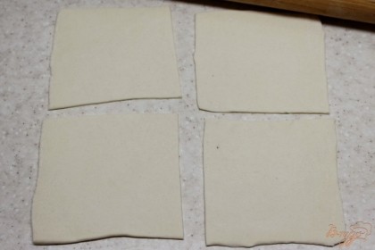 Слоеное тесто посыпаем мукой, раскатываем и режем на квадраты.