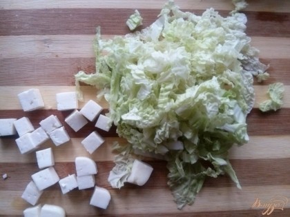 Нарежьте мелко пекинскую капусту. Сыр фета нарежьте кубиком.