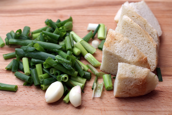 Отдельно взбейте в блендере мякиш подсушенного белого хлеба, чеснок, оливковое масло, соль и воду. Я добавила также зеленый лук и петрушку, но можно взять любую зелень, которая вам нравится.