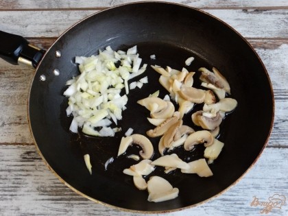 Пока варится картофель, приготовим пассировку. На сковороду поместим измельченный лук и консервированные грибы. Обжарим их на малом количестве растительного масла.