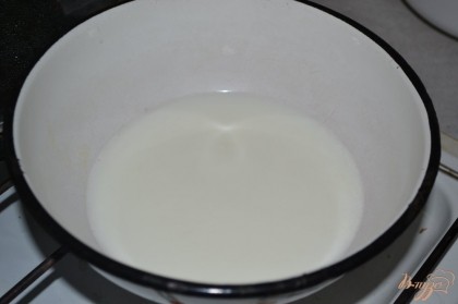 Молоко ставим на маленький огонь. Часть горячего молока вливаем к желткам и быстро перемешиваем.
