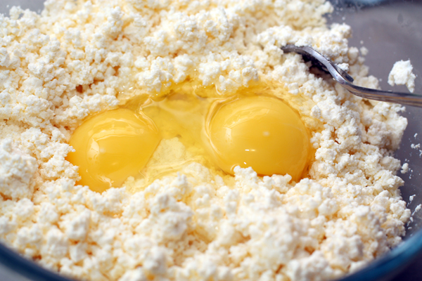 В это время разомните творог для начинки, добавьте яйца и посолите.