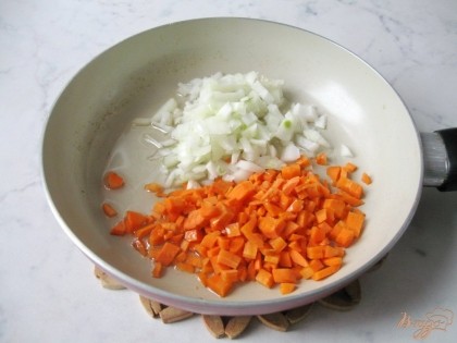 Мелко режем лук, морковь. Выкладываем на сковороду, наливаем подсолнечное масло и ставим тушить.