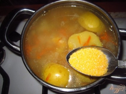 Добавьте в суп картофель и кукурузную крупу перемешайте и варите минут 15 до готовности супа.
