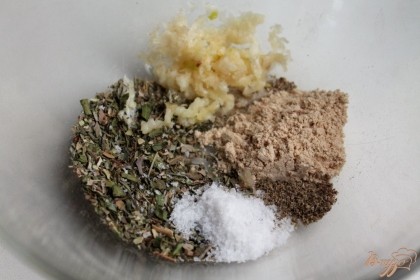 Готовим маринад. В пиалу насыпаем соль, прованские травы, молотый имбирь, черный молотый перец и добавляем пропущенный через пресс чеснок.