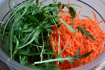 Морковь натереть тонко и уложить в салатник, добавить горсть рукколы. Перемешать.